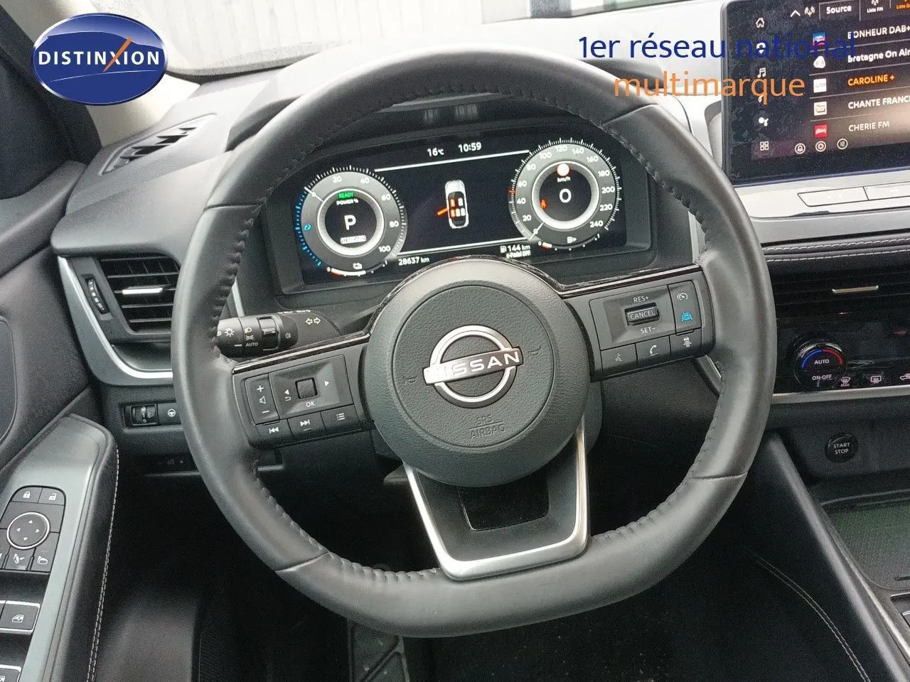 Vue intérieure centrée sur le volant cuir noir du Nissan Qashqai e-POWER 2025 avec tableau de bord digital et écran tactile.