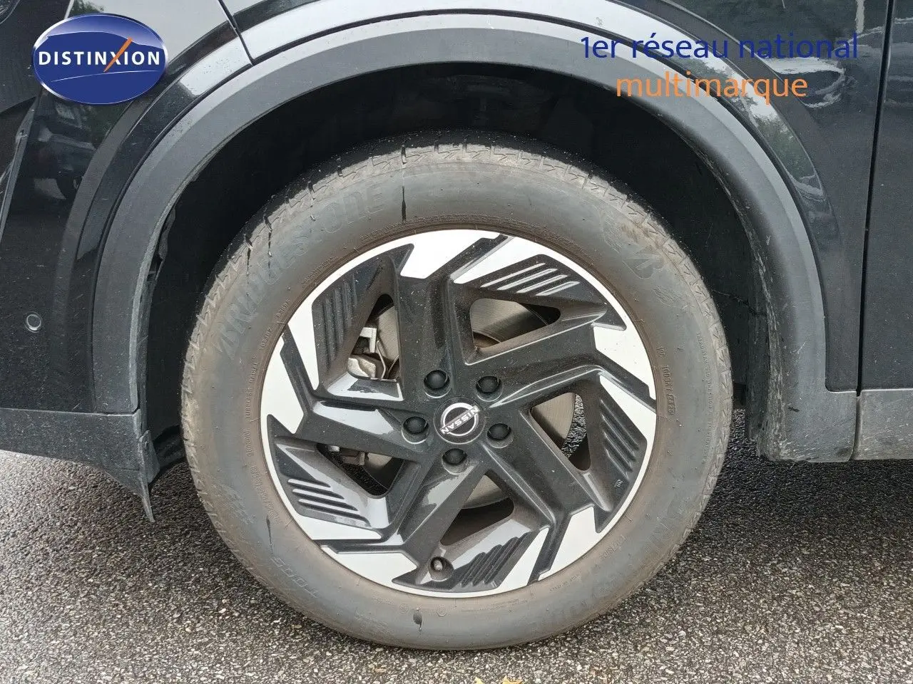 Gros plan sur la roue avant gauche noire Kuro Metal du Nissan Qashqai e-POWER 2025 avec jante design bicolore.