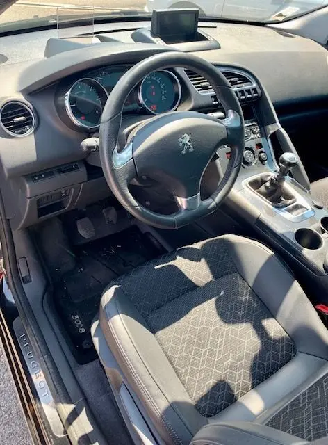 Intérieur de la Peugeot 3008 1.6 HDI115 Allure 2014, vue côté conducteur montrant volant, tableau de bord et levier manuel.