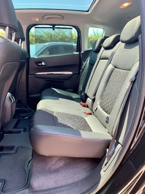 Vue latérale du siège arrière droit du Peugeot 3008 noir 2014 avec sellerie tissu et cuir, ouvrant sur une portière.