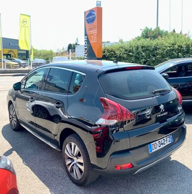 Peugeot 3008 noir 2014 vue 3/4 arrière côté gauche, avec feux arrière distinctifs et jantes alliage.