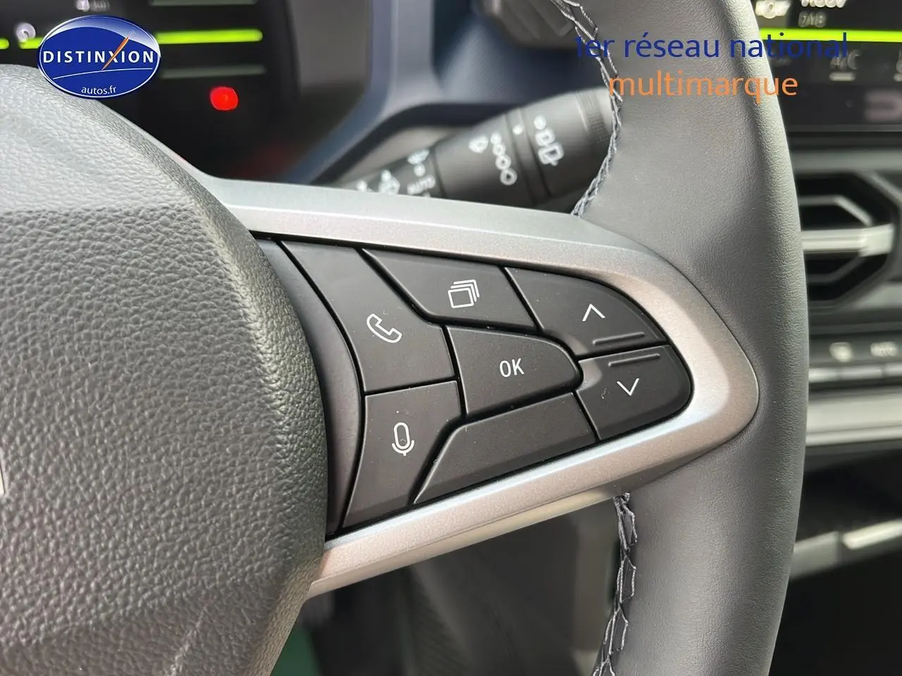 Gros plan sur les commandes multifonctions à droite du volant du Dacia Duster 2025, intérieur noir et gris.