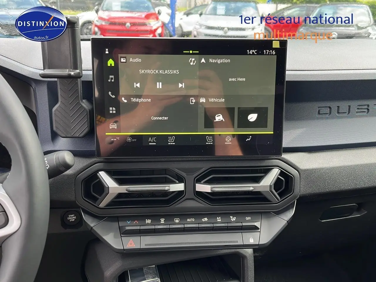 Vue intérieure du tableau de bord du Dacia Duster gris schiste 2025 avec écran tactile central et aérateurs hexagonaux.