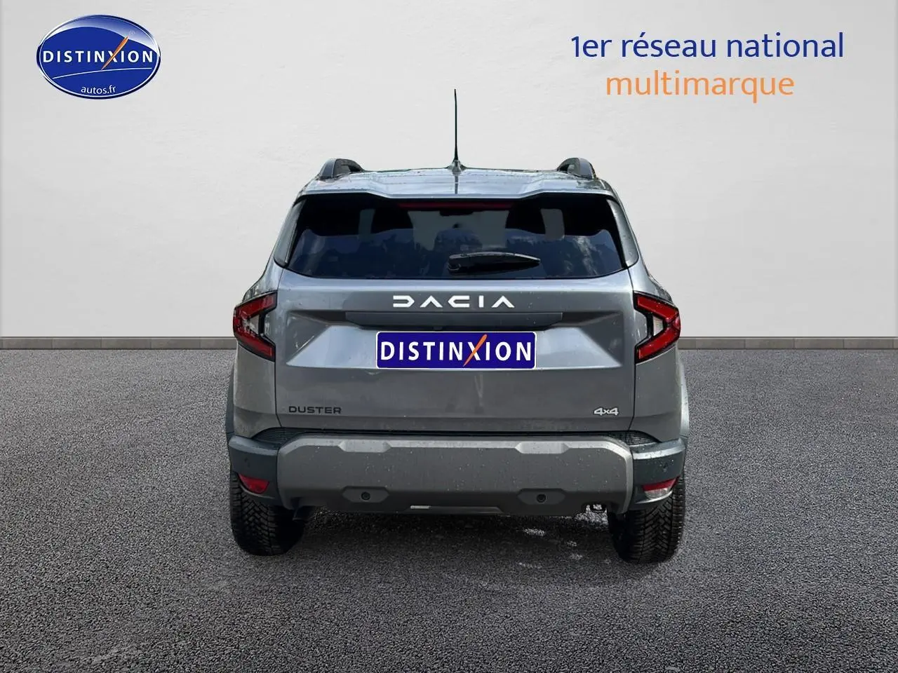Vue arrière du Dacia Duster gris schiste 2025 avec logo DACIA lumineux et plaques Distinxion visibles.