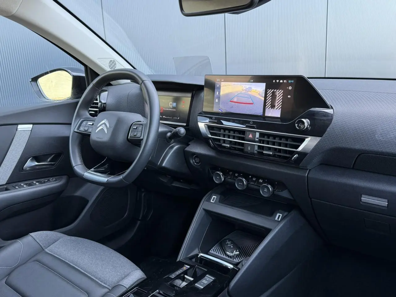 Intérieur avant droit de la Citroën C4 X 2024 noir Perla, avec écran tactile affichant la caméra de recul.