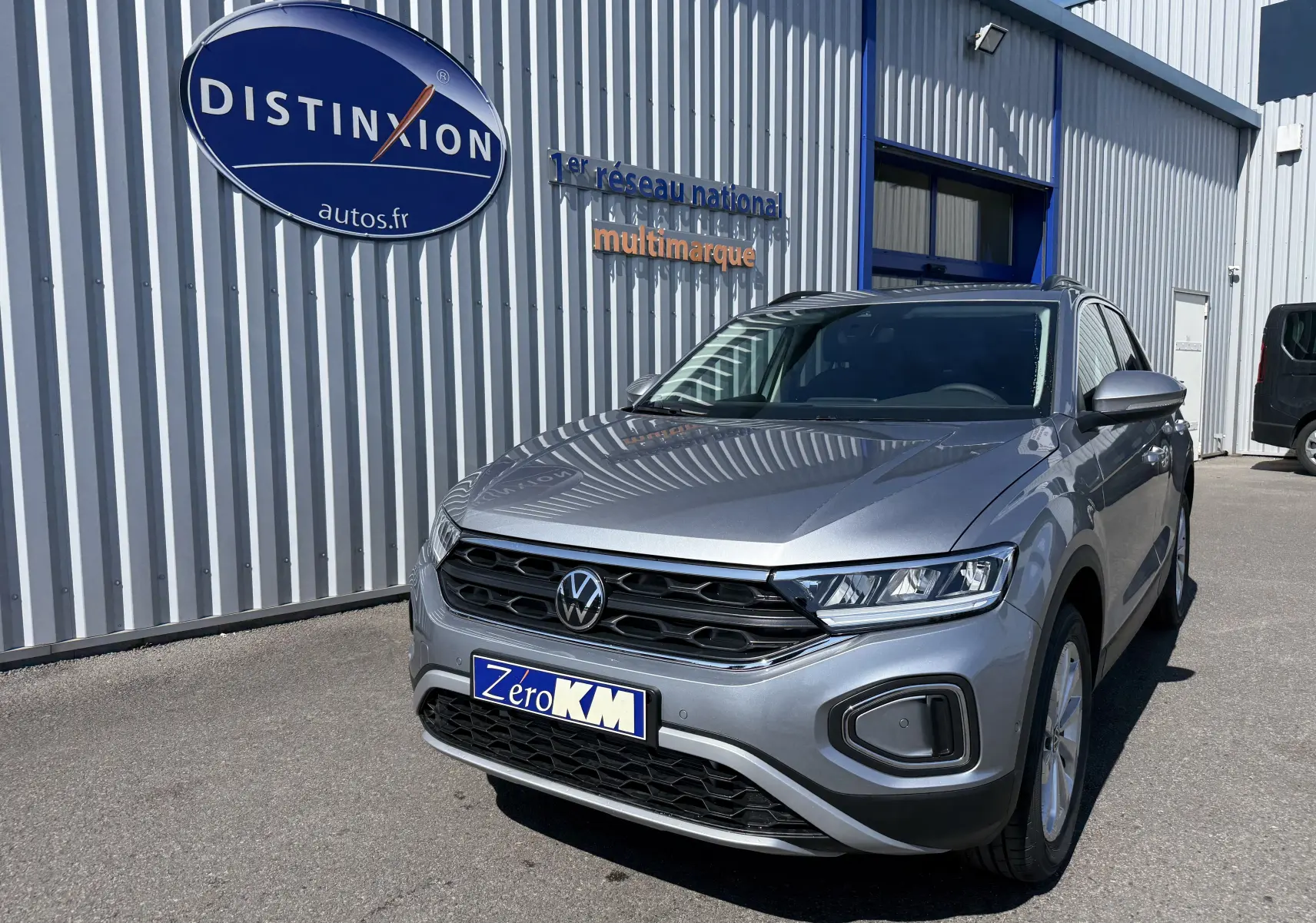 Volkswagen T-Roc gris pyrite en 3/4 avant droit, avec calandre noire et phares LED distinctifs.