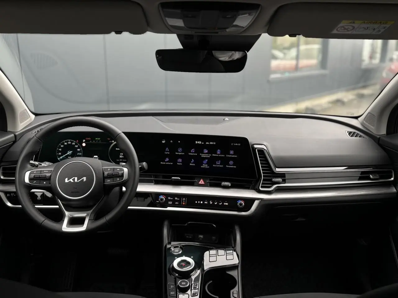 Vue intérieure du tableau de bord du Kia Sportage 2025 avec volant cuir et écran tactile 12,3 pouces.