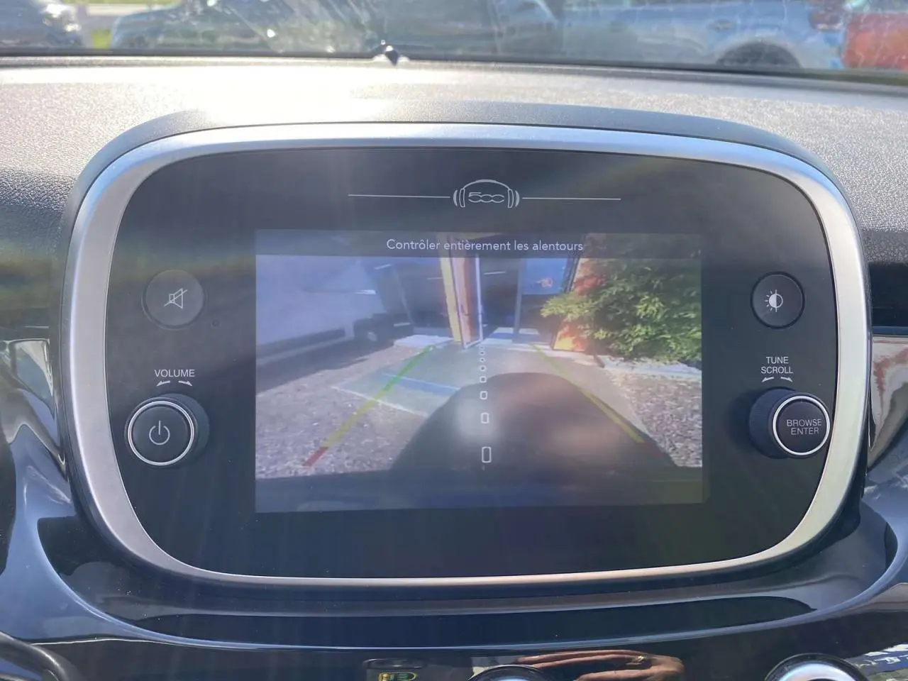 Écran central de la Fiat 500X noir montrant la caméra de recul avec lignes de guidage colorées.