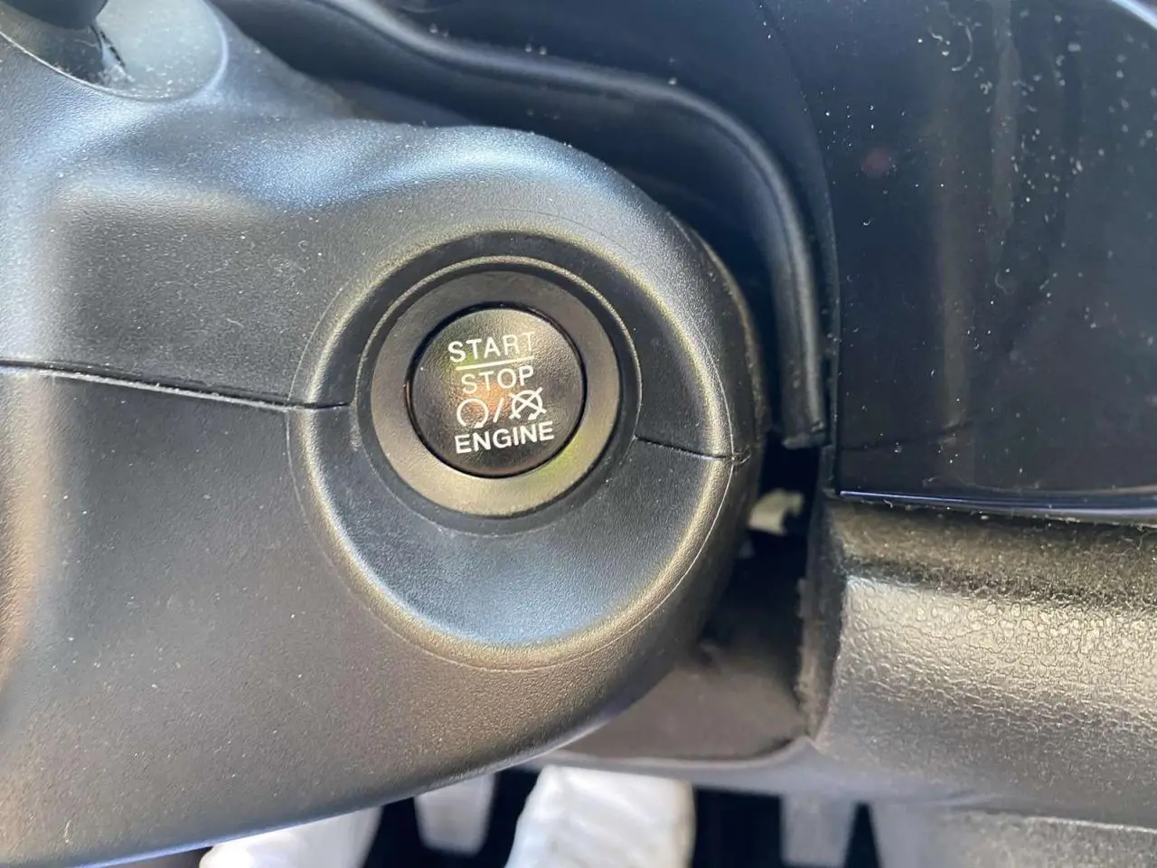 Bouton start/stop moteur en gros plan sur le tableau de bord du Fiat 500X noir de 2019.