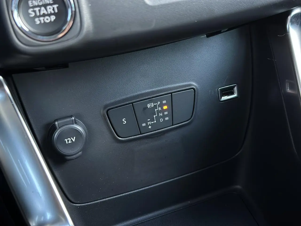 Vue rapprochée de la console centrale de la Citroën C3 Aircross 2024, bouton start/stop visible, finition noire.