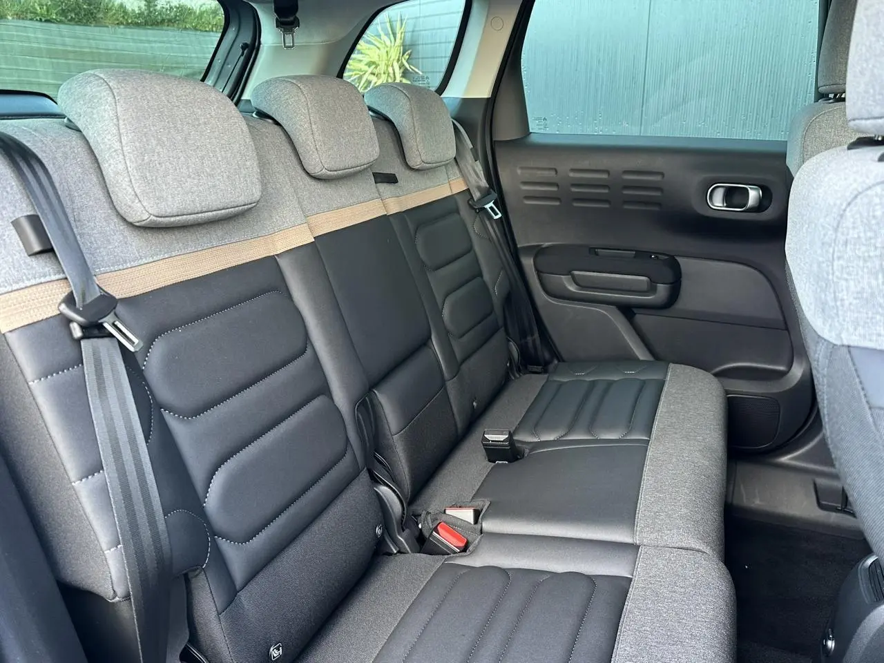 Vue intérieure de la banquette arrière bicolore gris clair et noir du Citroën C3 Aircross 2024 côté droit.