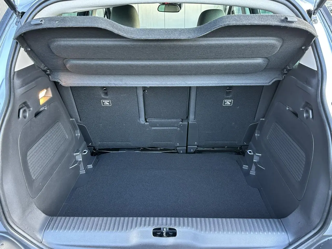 Coffre ouvert du Citroën C3 Aircross gris Artense, montrant la banquette arrière coulissante et le plancher modulable.