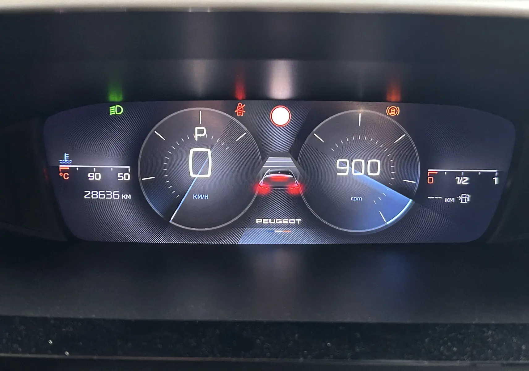 Tableau de bord numérique de Peugeot 308 2024 affichant vitesse, régime moteur, température et alertes au centre.