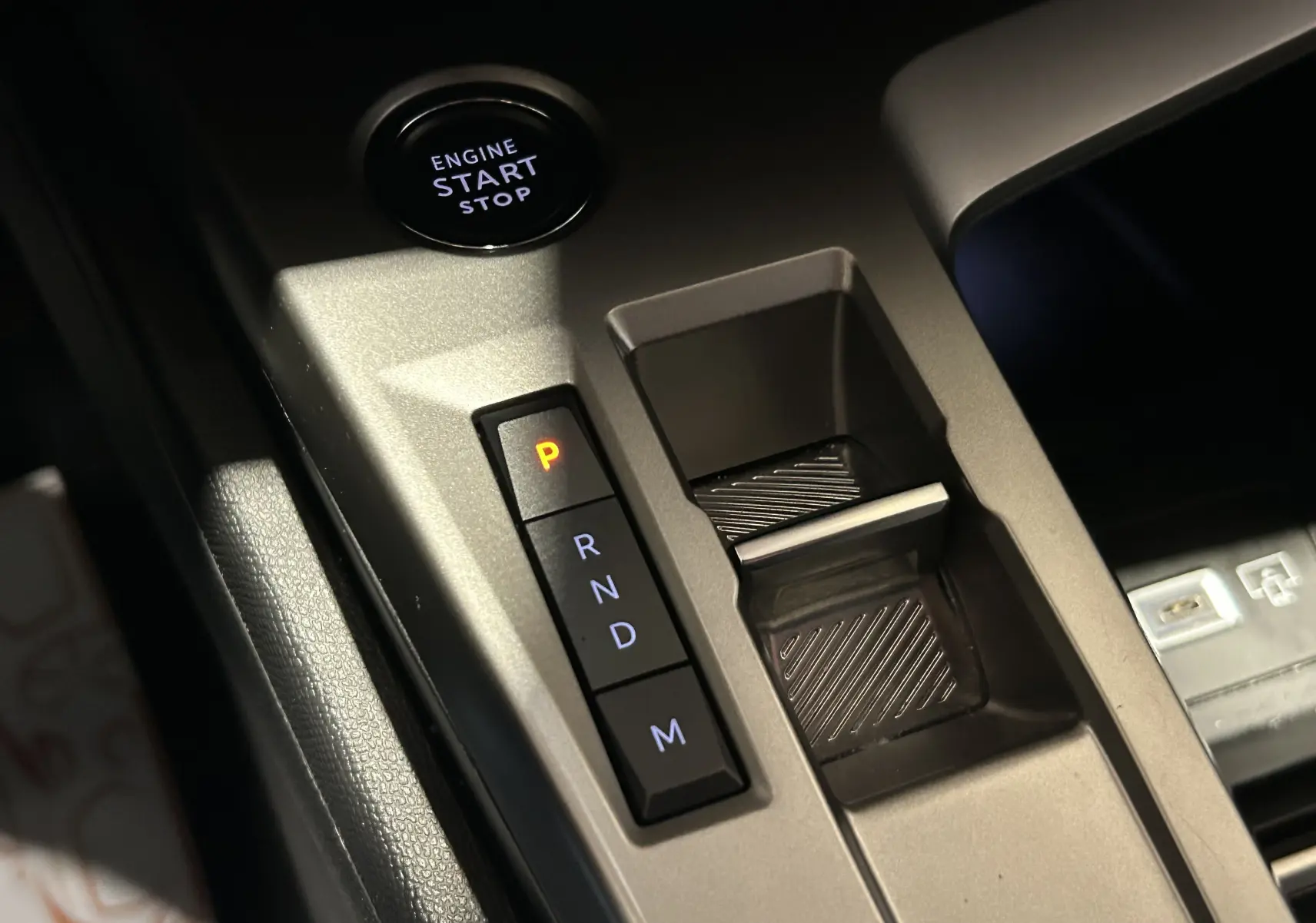 Gros plan sur la console centrale de la Peugeot 308 2024, montrant le bouton start/stop et la commande de boîte automatique.