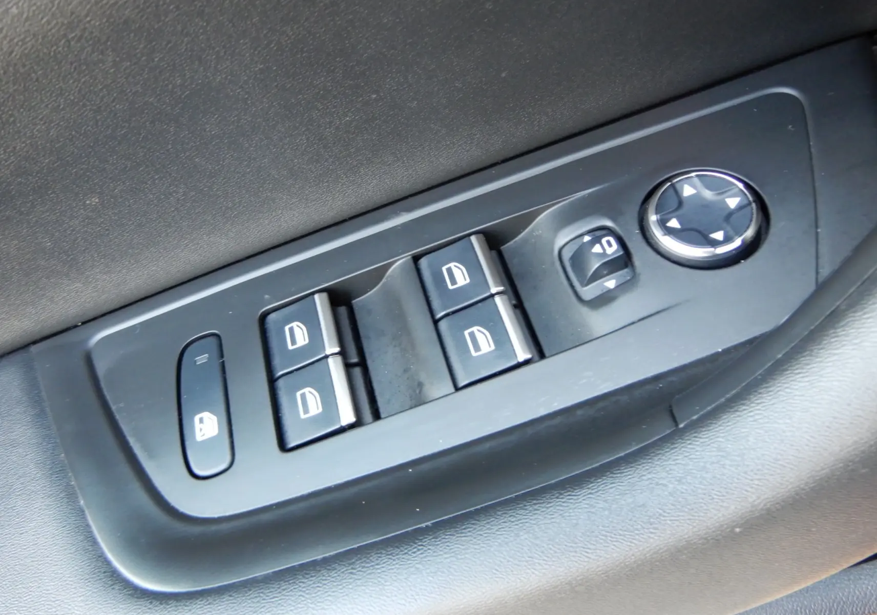 Panneau de commandes des vitres électriques et réglage des rétroviseurs côté conducteur dans l'habitacle noir du Peugeot 508 SW 2020.