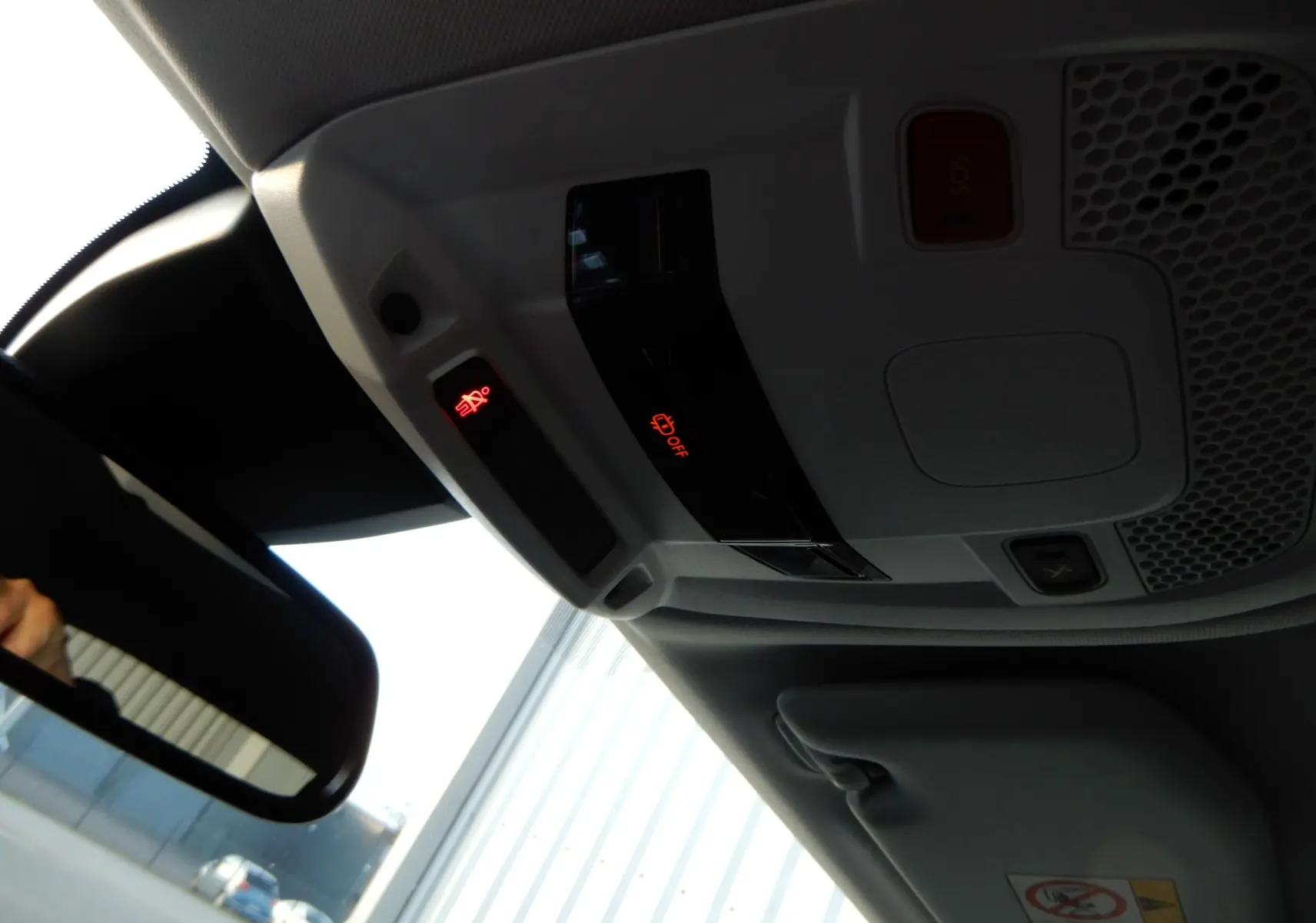 Vue intérieure du plafonnier et du rétroviseur d'un Peugeot 508 SW noir Perla Nera avec témoins lumineux rouges.