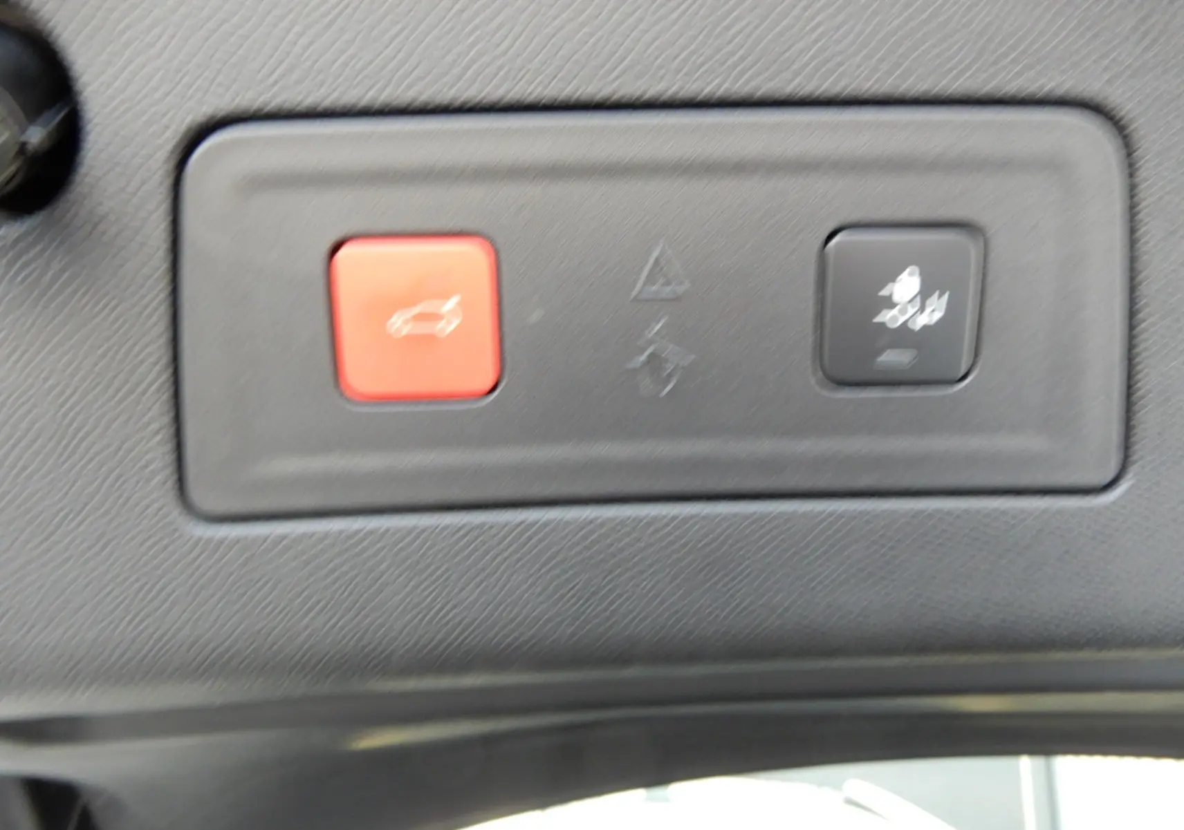 Gros plan sur les boutons d'ouverture du hayon et de désactivation de l'alerte de recul dans un Peugeot 508 SW noir.