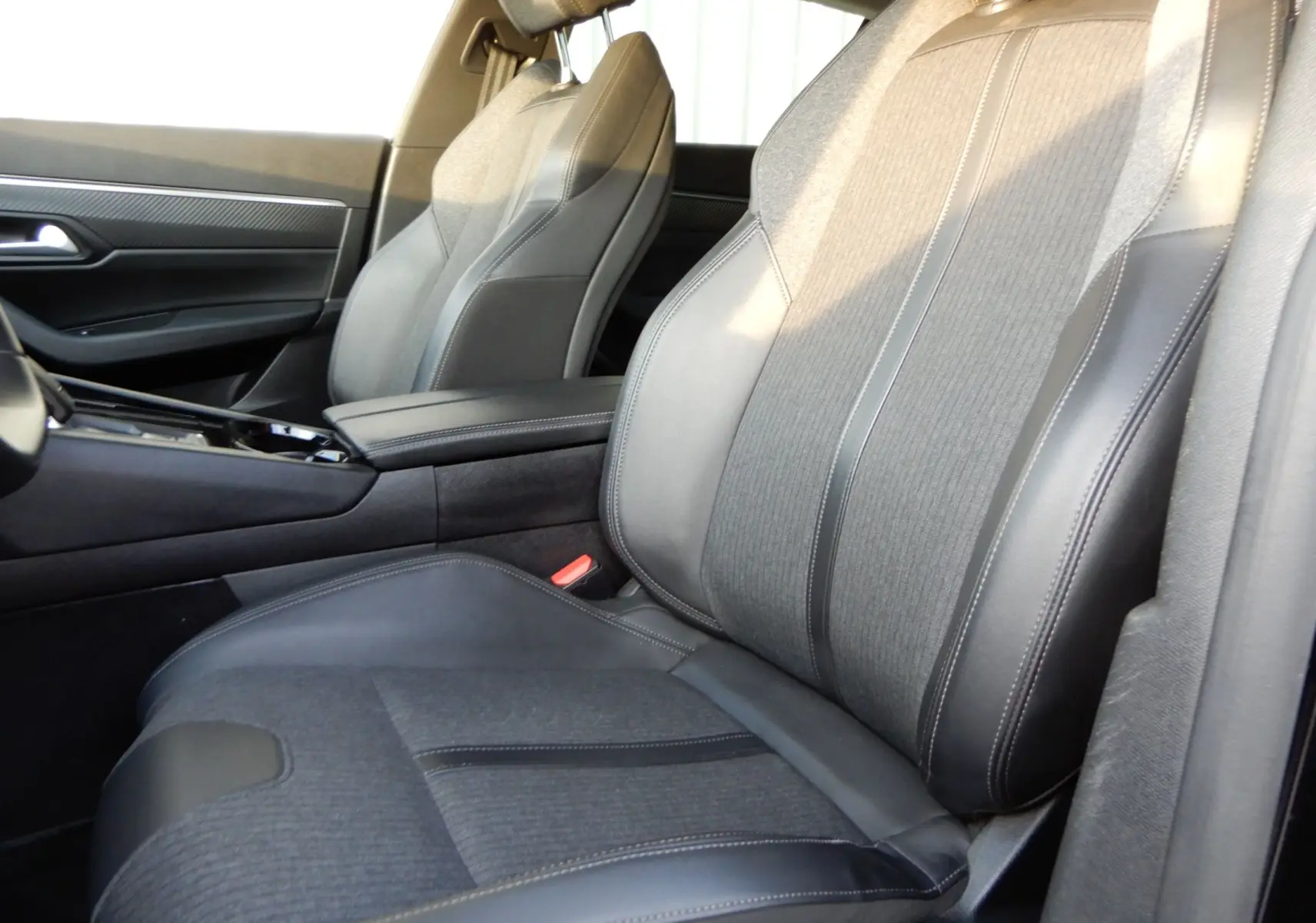 Vue rapprochée des sièges avant en tissu et cuir noir de la Peugeot 508 SW Allure 2020, côté droit intérieur.