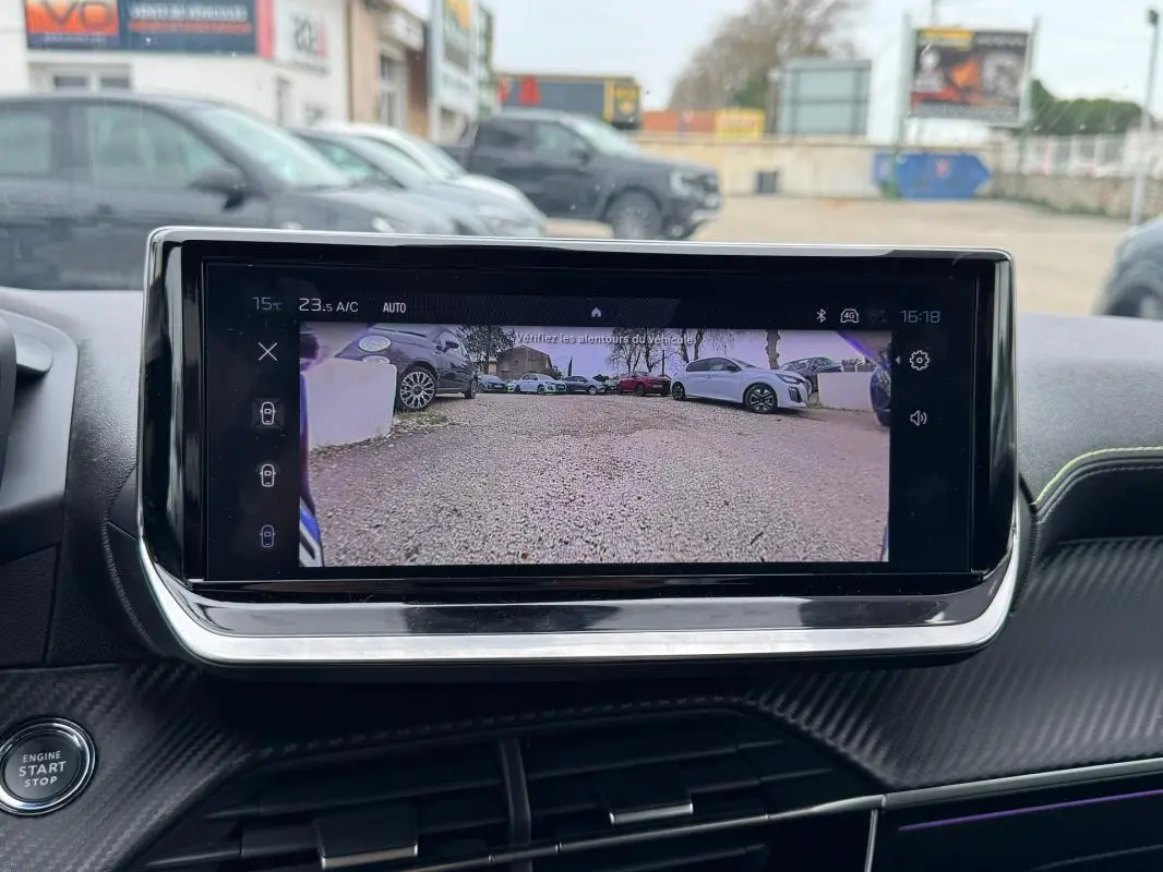 Vue intérieure centrée sur l'écran tactile affichant la caméra de recul d'une Peugeot 208 gris 2025.