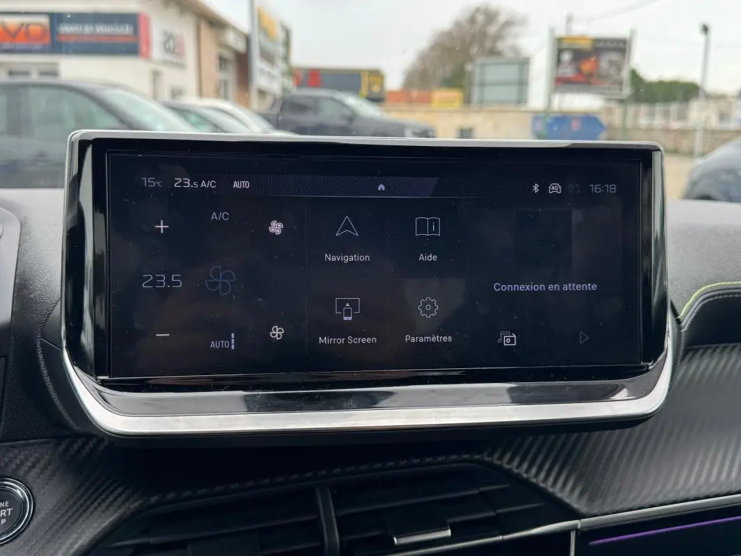 Écran tactile central affichant la climatisation et navigation dans l’habitacle d’une Peugeot 208 gris, vue de face.