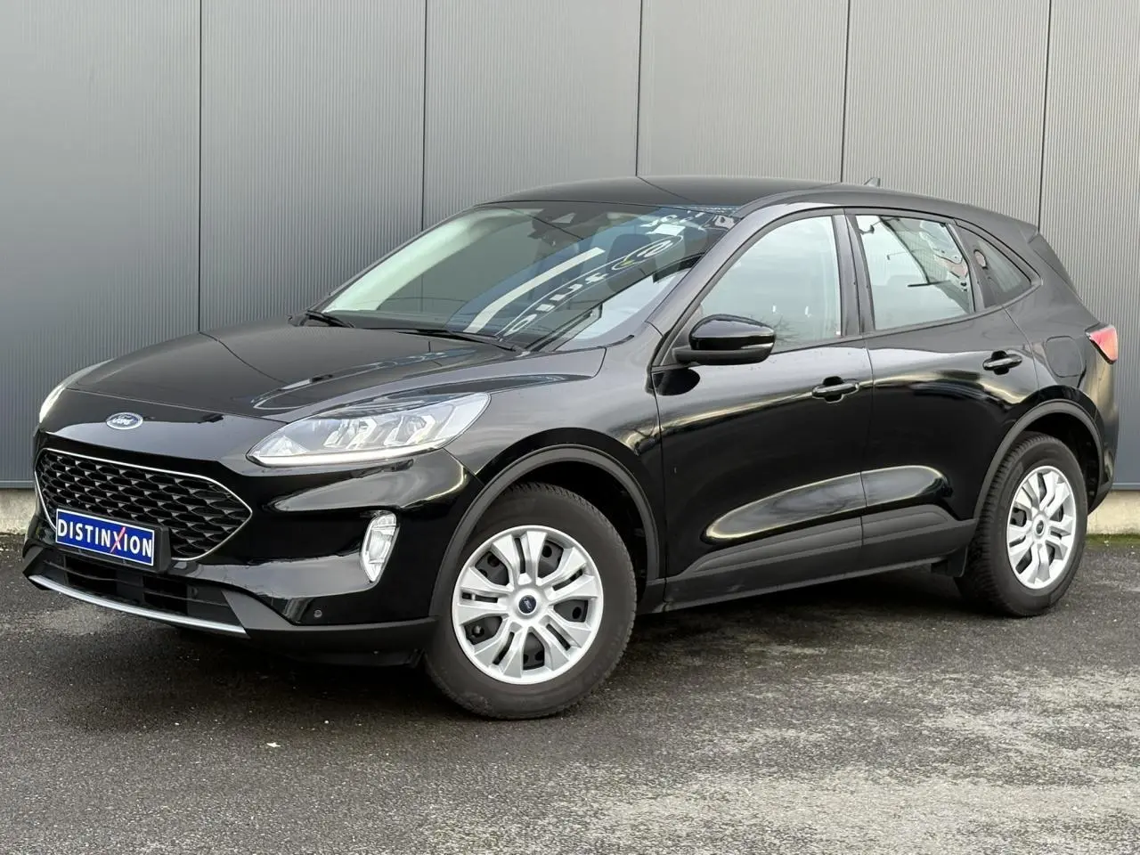Ford Kuga noir Obsidien en 3/4 avant droit, mettant en valeur sa calandre large et ses jantes argentées.