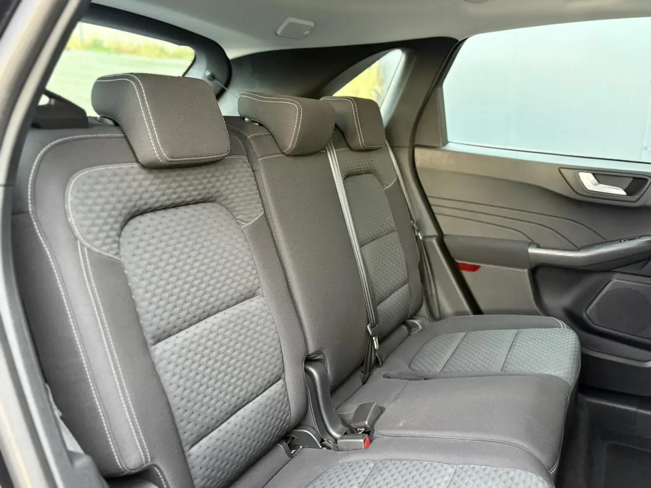 Vue intérieure côté droit des sièges arrière gris texturés du Ford Kuga 2024, finition Cool & Connect.