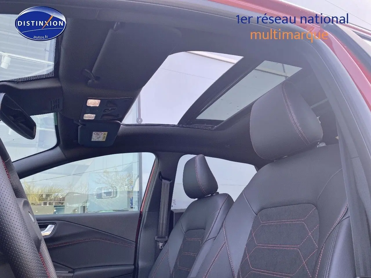 Vue intérieure côté gauche du Ford Puma rouge avec toit ouvrant panoramique et sièges sport noirs à surpiqûres rouges.