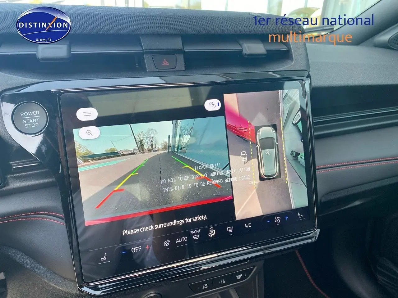 Vue rapprochée de l'écran tactile intérieur du Ford Puma rouge, affichant la caméra de recul et la vue à 360 degrés.