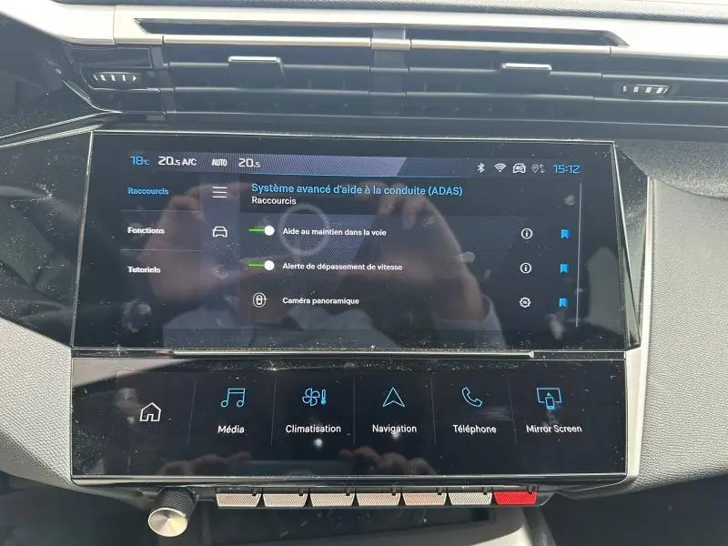 Vue rapprochée de l’écran tactile central du Peugeot 308 blanc Okénite, affichant le système d’aide à la conduite.