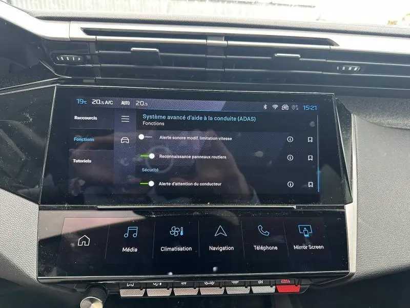 Vue rapprochée de l’écran tactile central du tableau de bord de la Peugeot 308 Hybrid 2025 affichant les aides à la conduite.