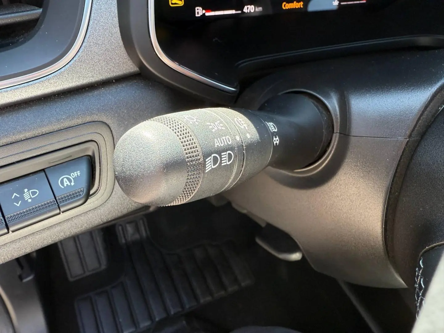 Gros plan sur la commande des phares et essuie-glaces dans l'habitacle noir du Renault Captur 2025.