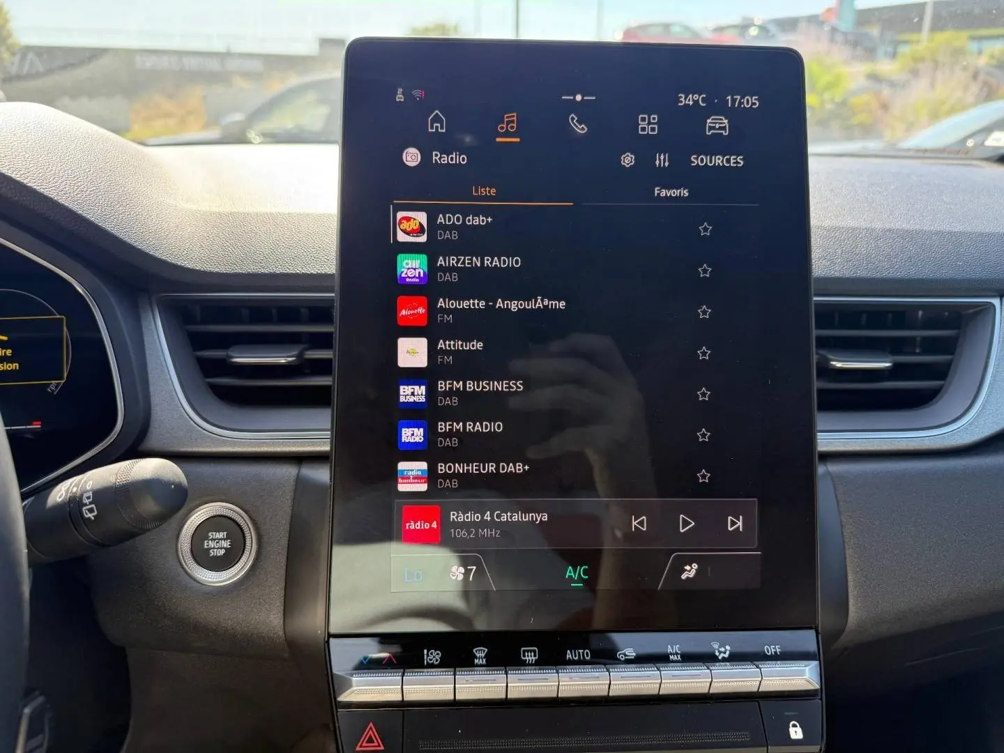 Écran tactile central du tableau de bord du Renault Captur 2025, affichant les options radio et climatisation.