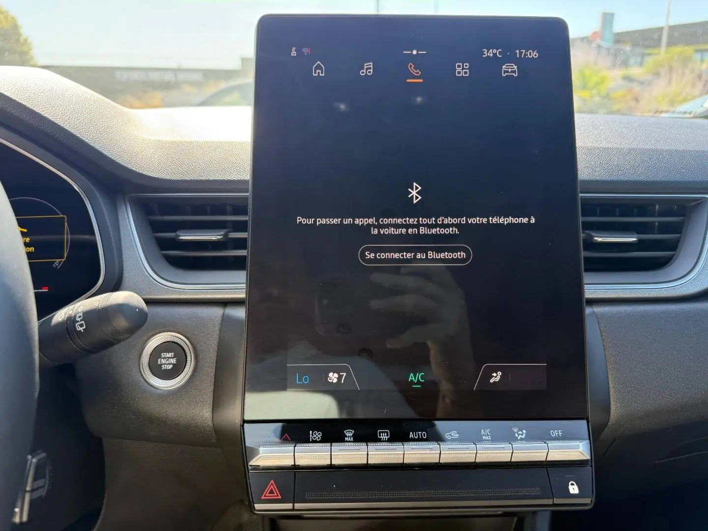 Vue rapprochée de l’écran tactile central et du bouton start/stop du tableau de bord du Renault Captur gris métallisé 2025.