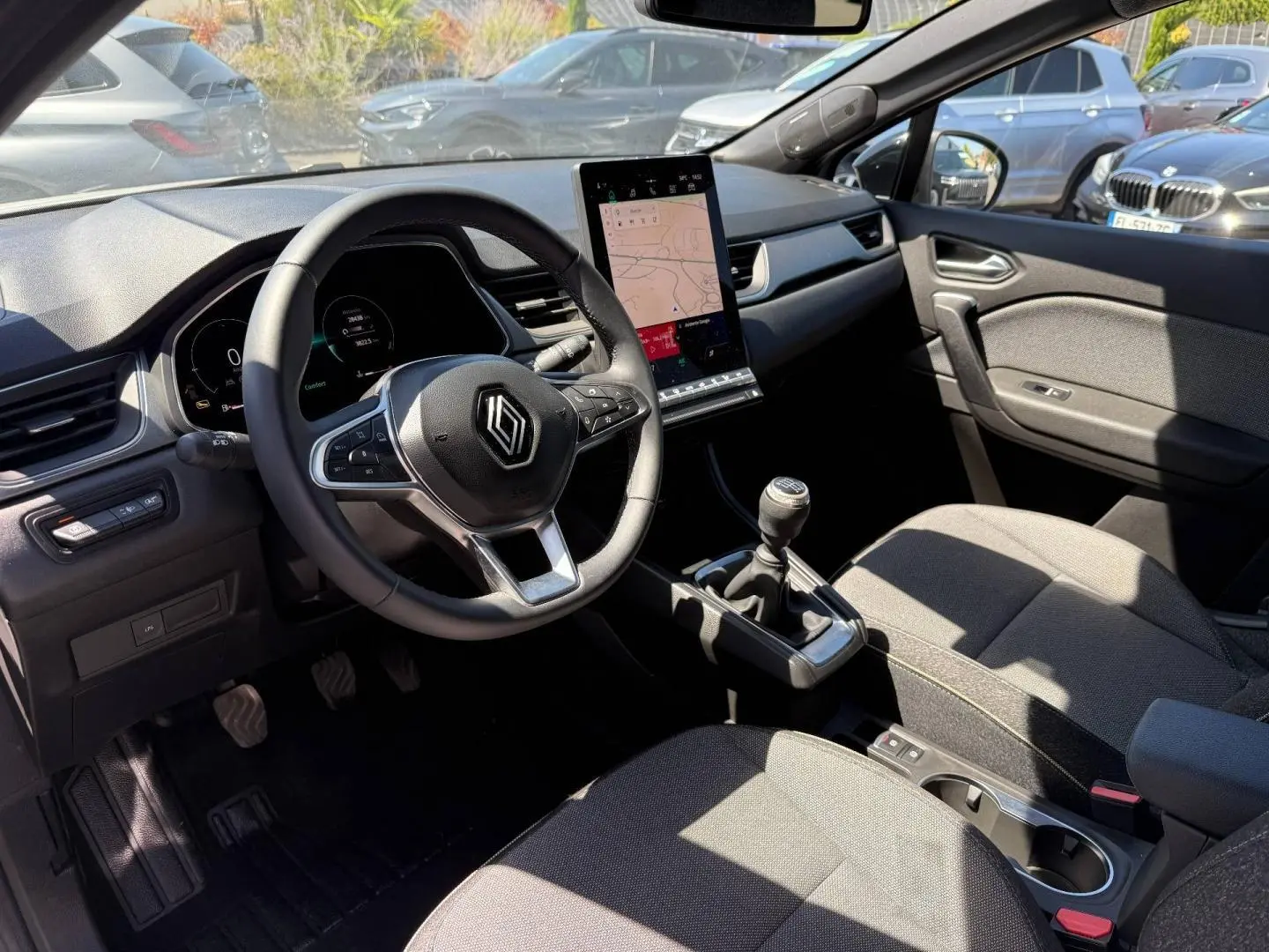 Vue intérieure côté conducteur du Renault Captur 2025 avec tableau de bord noir et écran tactile vertical.