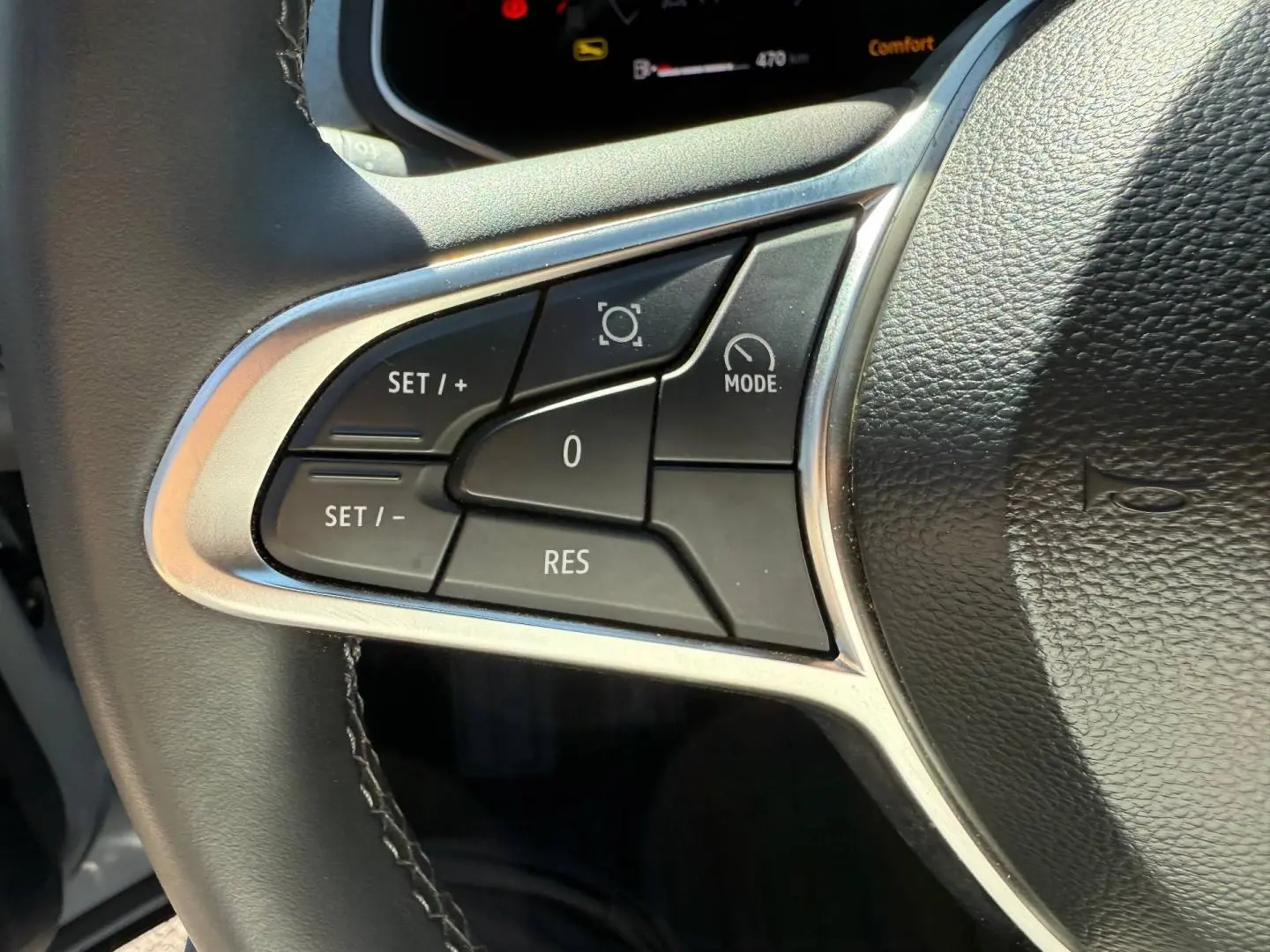 Gros plan sur les commandes multifonctions à gauche du volant noir du Renault Captur 2025, boutons de régulateur de vitesse.