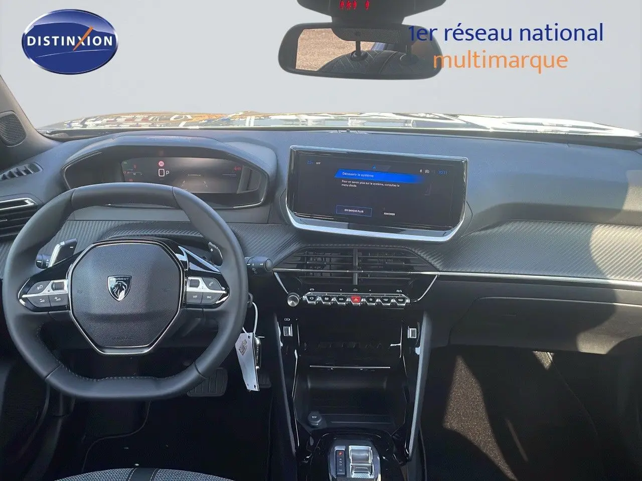 Vue intérieure frontale du tableau de bord du Peugeot 2008 Hybrid gris avec écran tactile et volant compact multifonction.