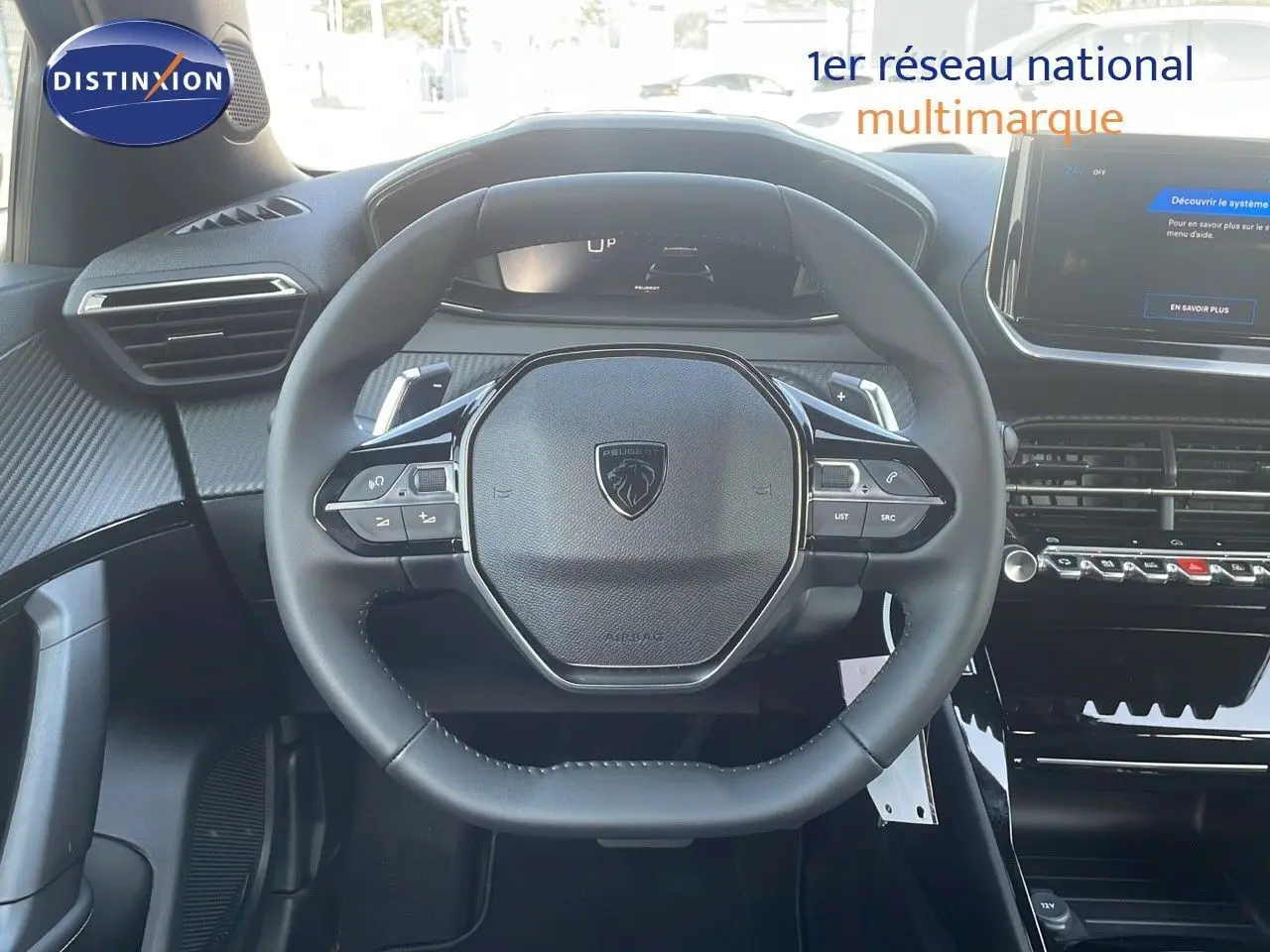 Vue rapprochée du volant cuir noir du Peugeot 2008 Hybrid 136ch avec tableau de bord numérique et console centrale moderne.