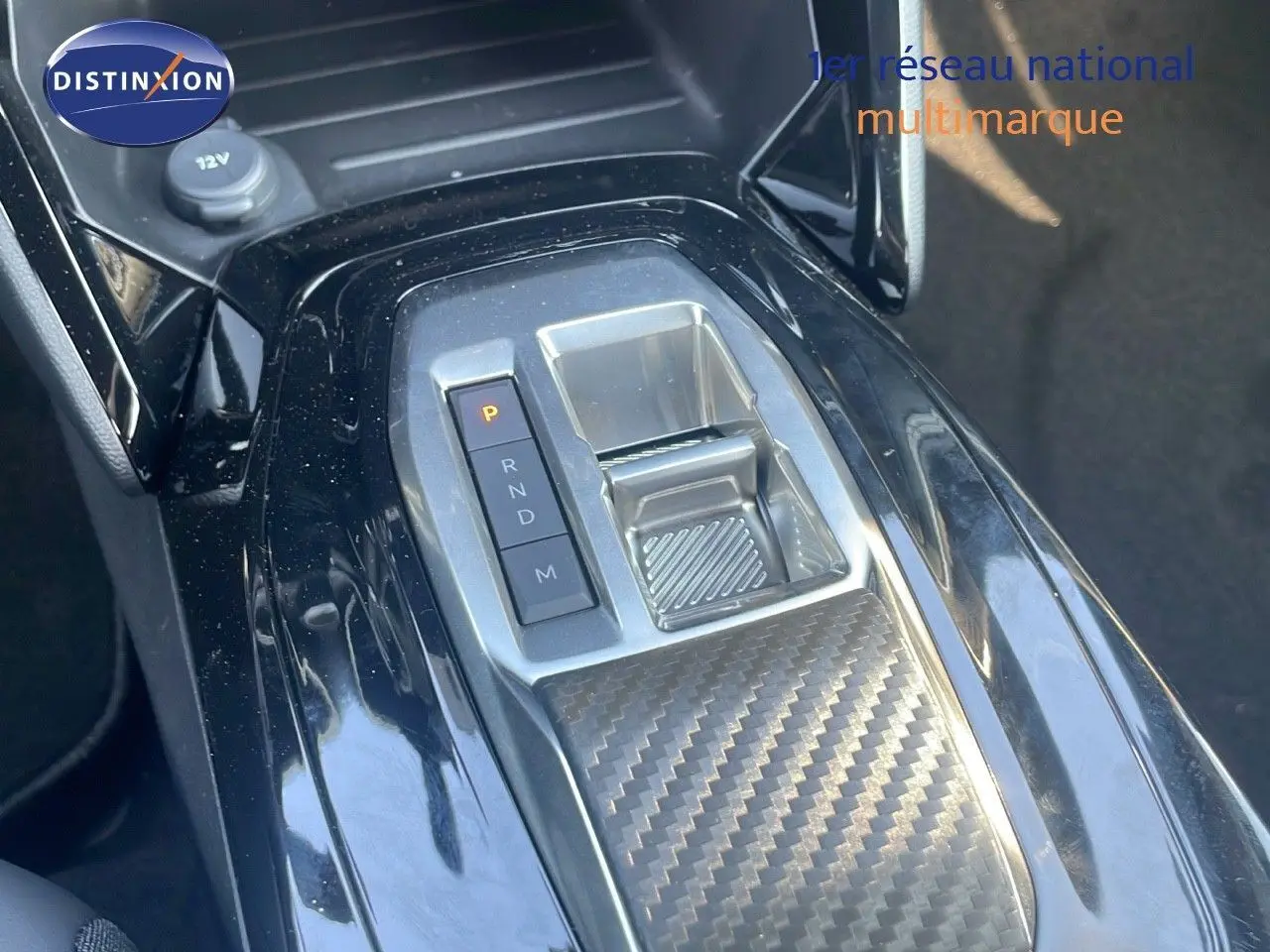 Gros plan sur la console centrale avec la commande de boîte automatique et finition carbone du Peugeot 2008 gris Artense 2025.