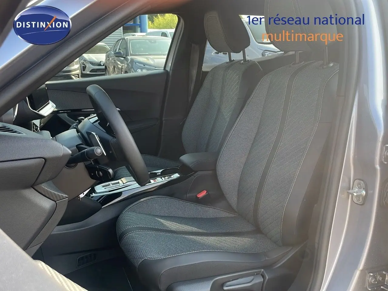 Intérieur du Peugeot 2008 Hybrid 136ch Allure 2025, vue côté conducteur, sièges tissu gris et cuir noir, console centrale moderne.