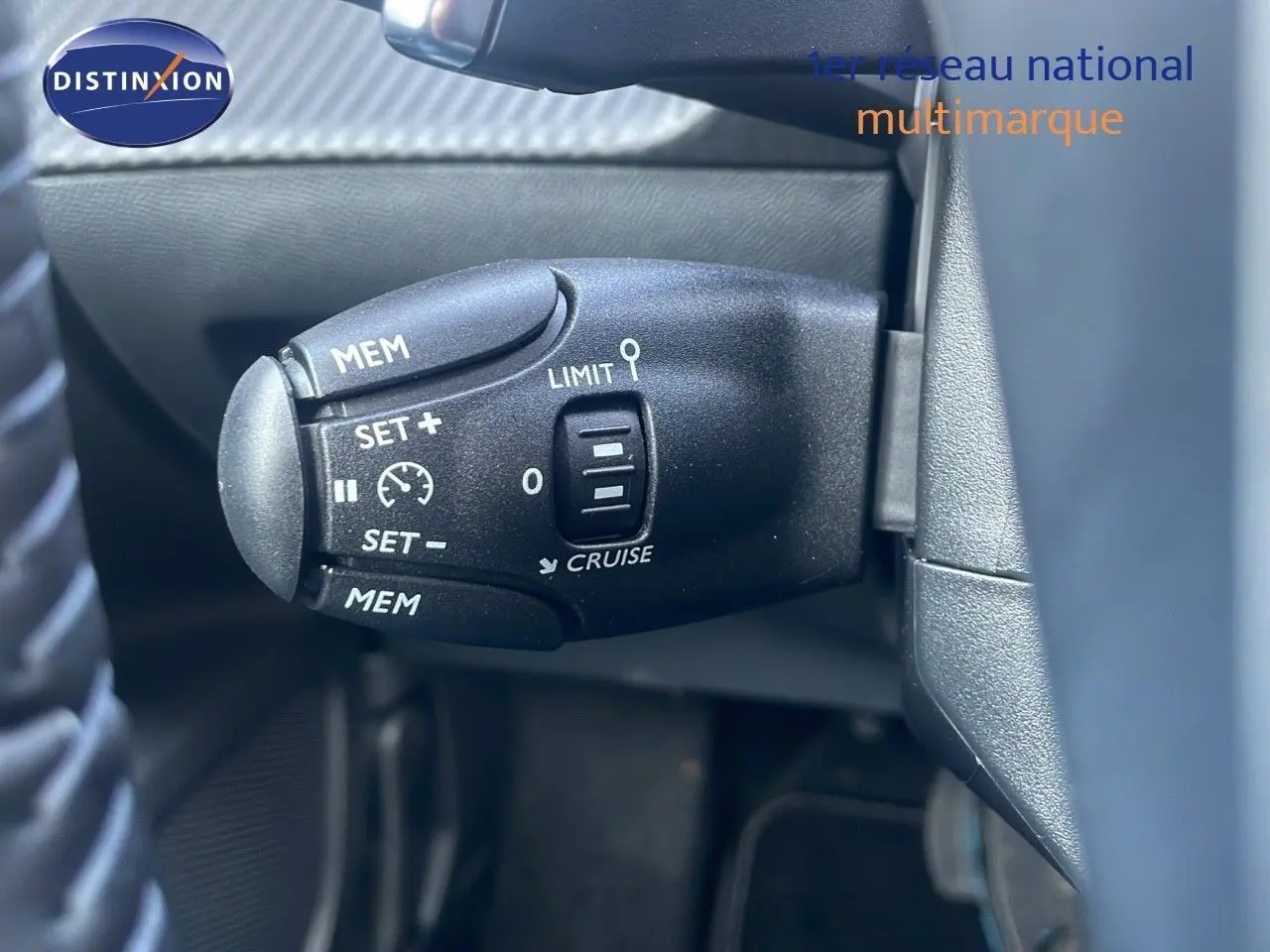 Gros plan sur la commande de régulateur de vitesse à gauche du volant d’un Peugeot 2008 gris Artense Metal 2025.