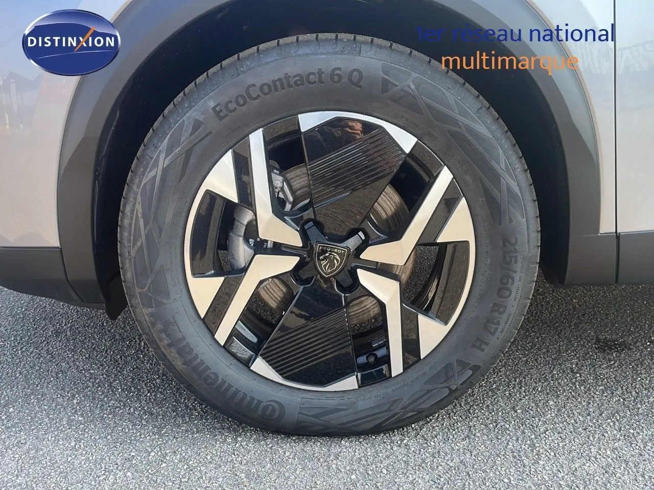 Gros plan sur la roue avant gauche du Peugeot 2008 gris Artense Metal, mettant en valeur la jante bi-ton moderne.