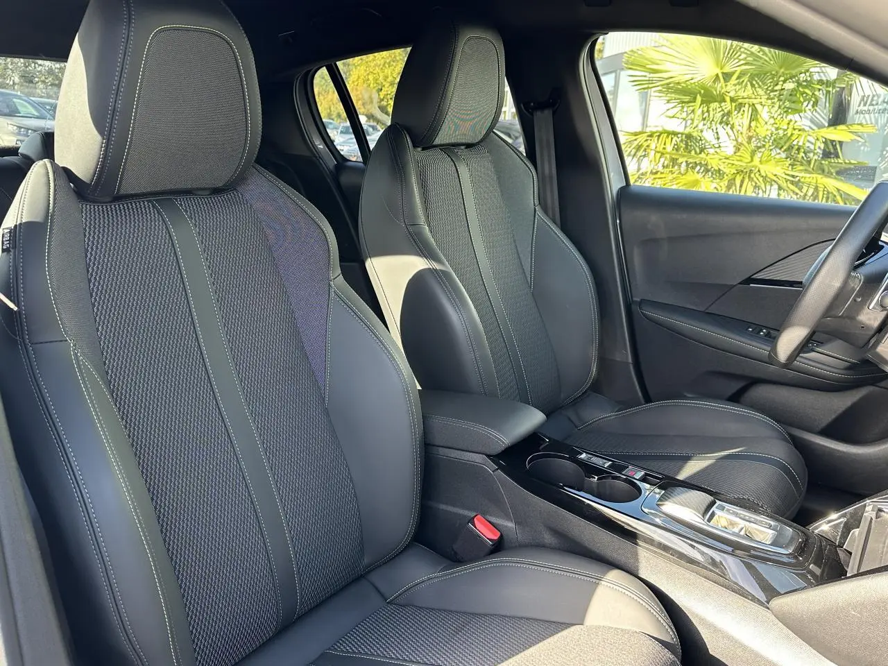 Vue intérieure côté droit des sièges avant en tissu noir avec surpiqûres vertes du Peugeot 208 Hybrid 145 e-DSC6 GT 2024