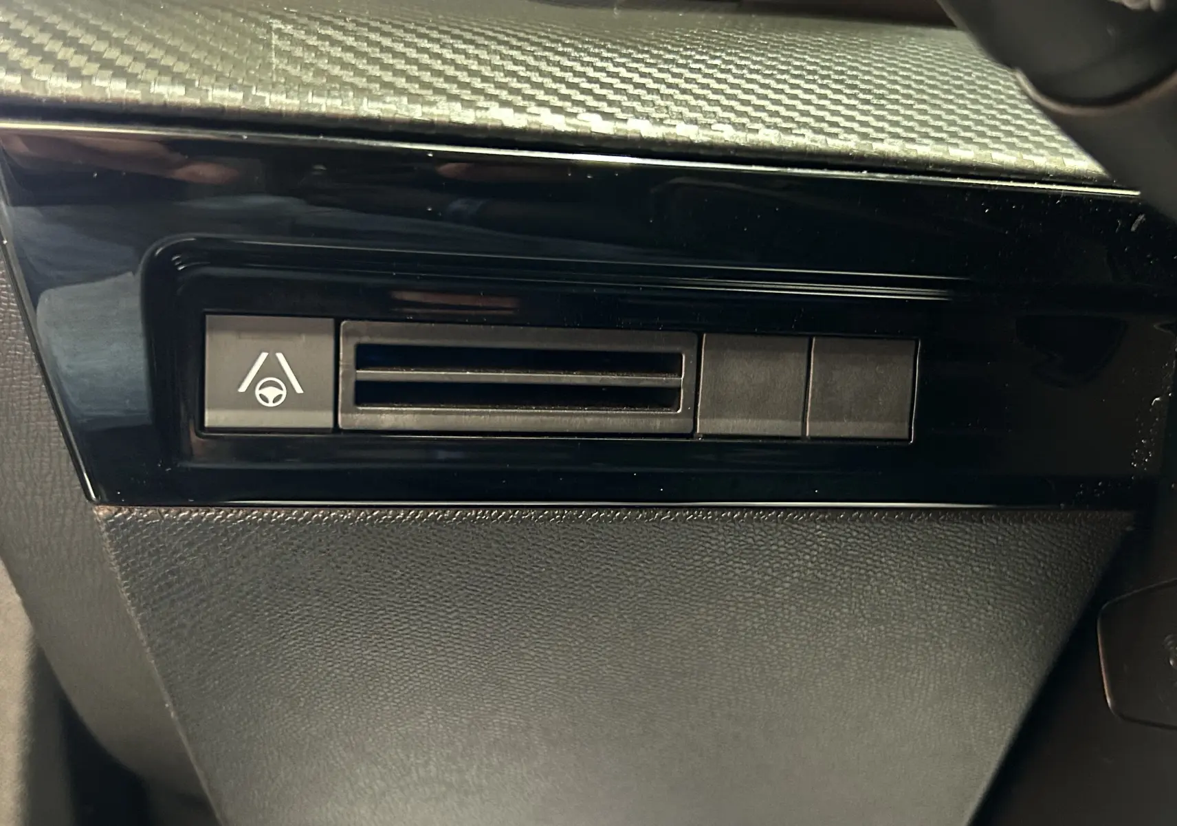 Détail du tableau de bord noir de la Peugeot 508 SW 2024 avec bouton d'assistance au maintien de voie visible.