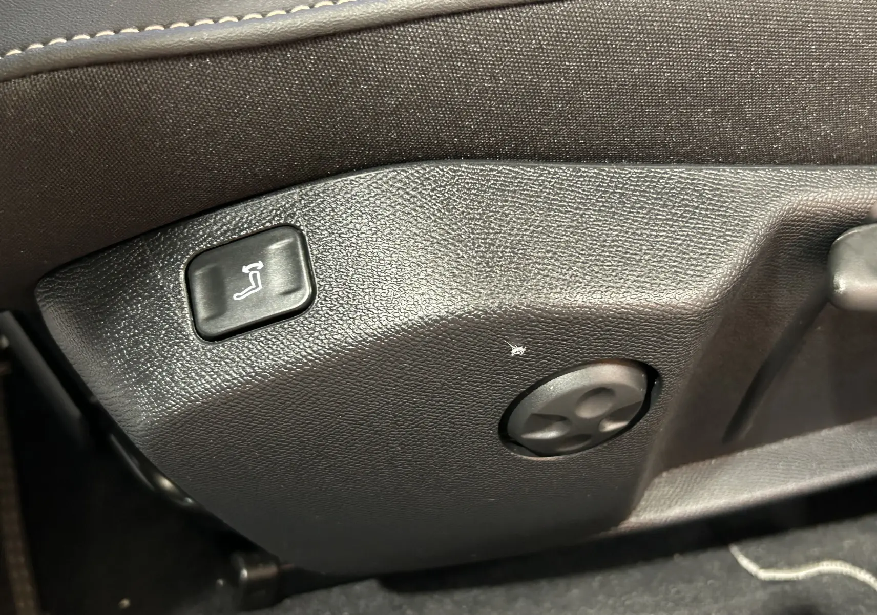 Gros plan sur les commandes de réglage du siège côté conducteur d'une Peugeot 508 SW gris artense, finition GT.