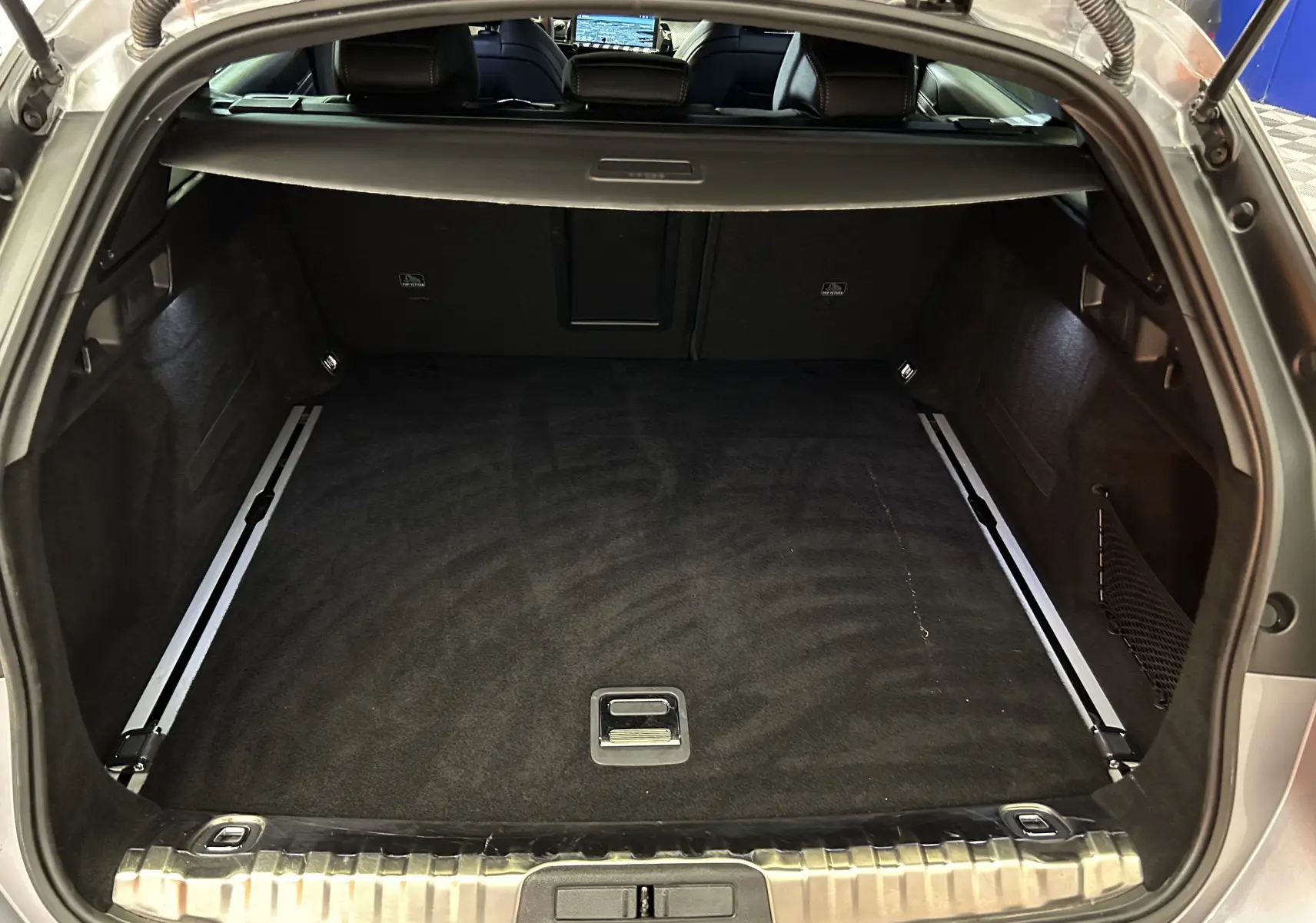 Coffre ouvert d'une Peugeot 508 SW Gris Artense 2024, vue arrière montrant l'espace de chargement et la plage arrière.