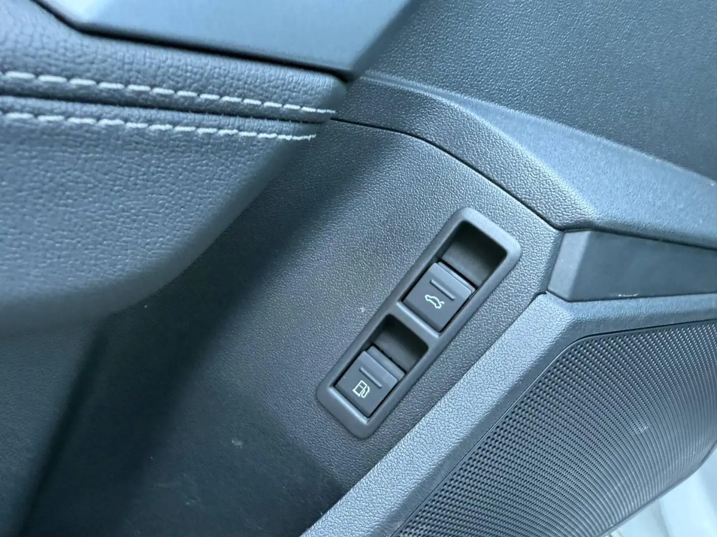 Détail intérieur côté conducteur de l'Audi A3 Sportback 2025 blanc Glacier, avec commandes ouverture coffre et trappe carburant.
