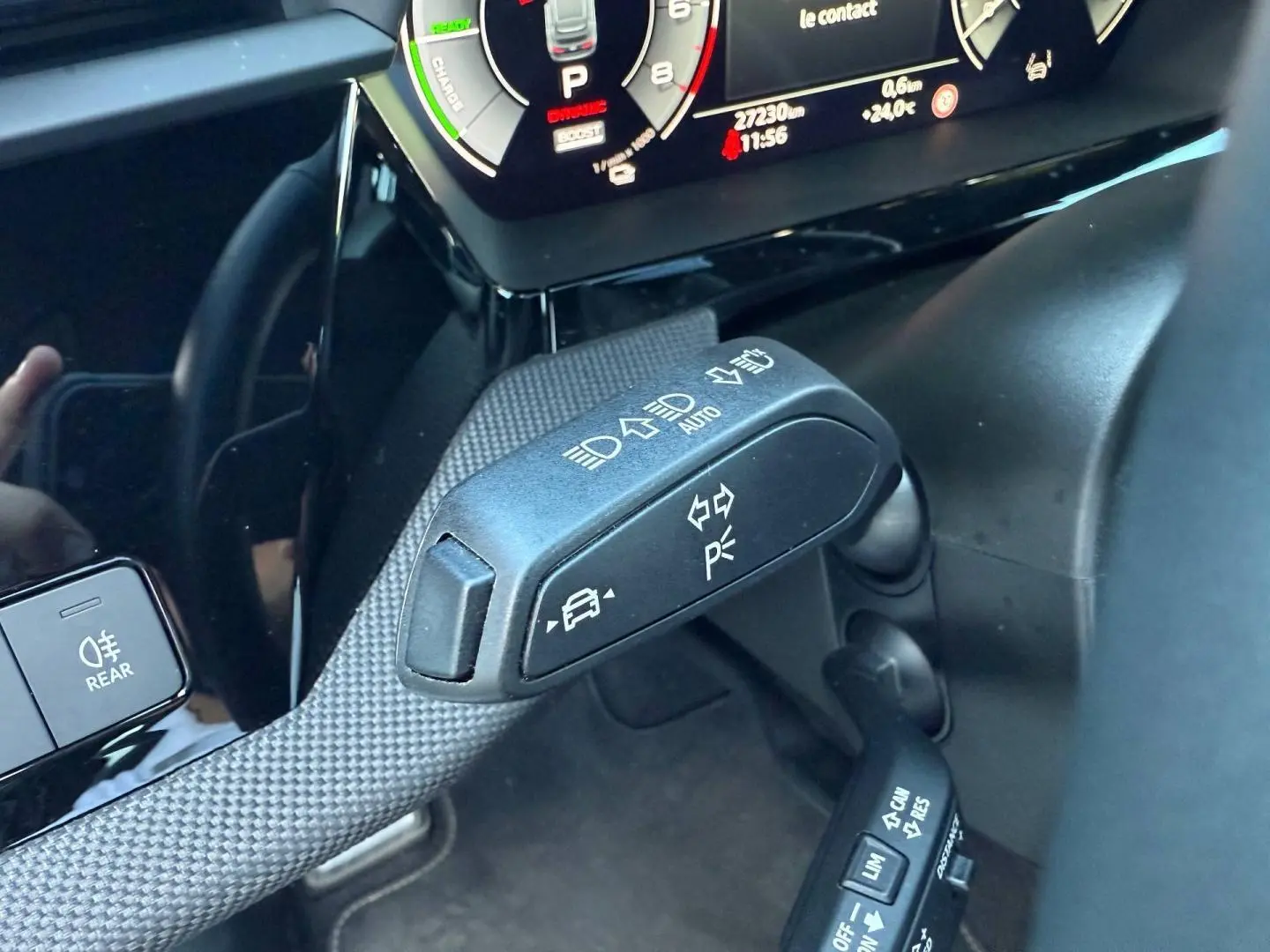 Gros plan sur la commande multifonction côté gauche du volant de l'Audi A3 Sportback blanc Glacier, avec tableau de bord numérique.
