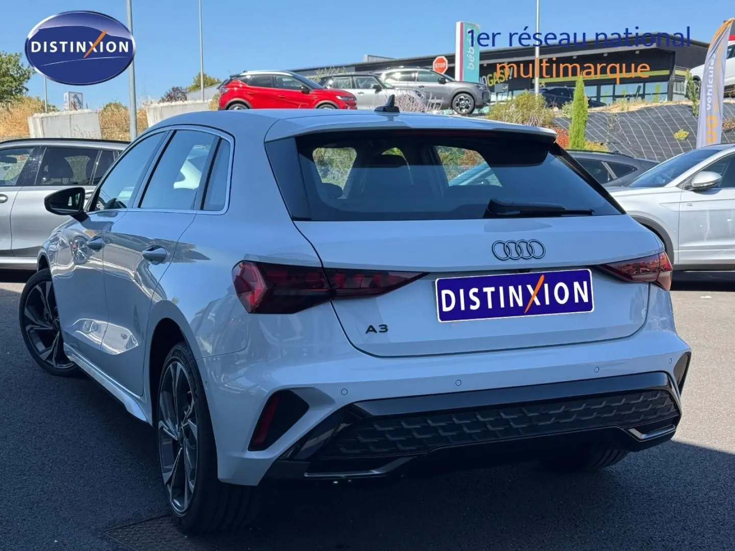 Audi A3 Sportback blanc Glacier métallisé vue 3/4 arrière droit, avec jantes alu et becquet arrière noir.