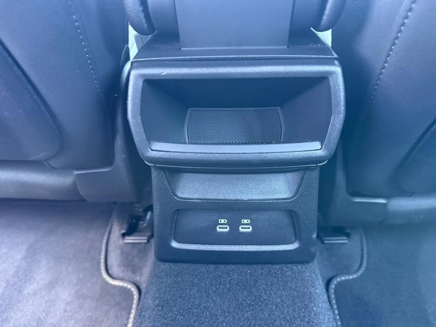 Détail de la console arrière noire avec deux ports USB-C, entre les sièges avant noirs de l'Audi A3 Sportback.