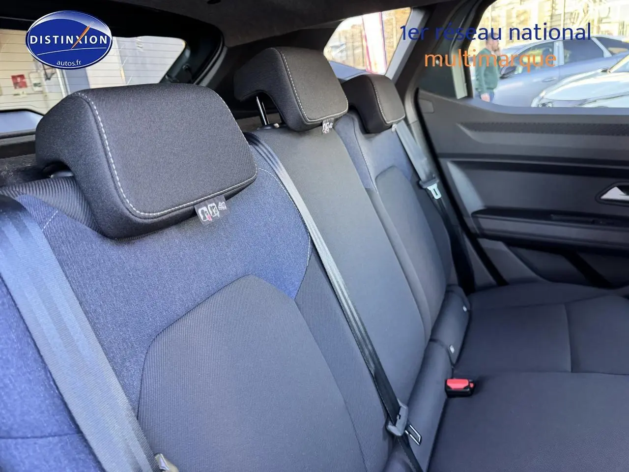 Vue intérieure du siège arrière côté droit du Dacia Duster 2025, tissu noir et bleu, avec ceintures de sécurité visibles.